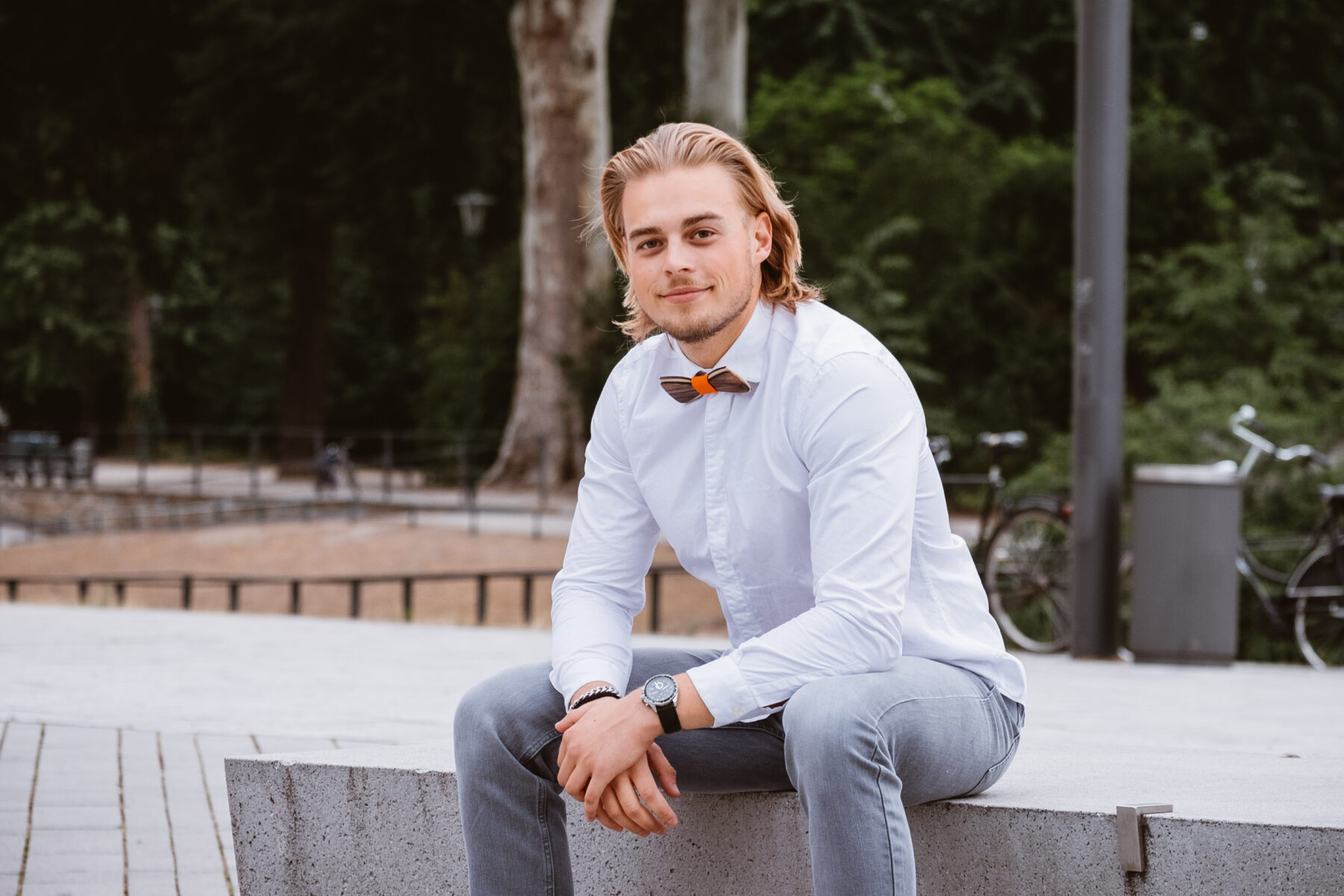 Junger Mann sitzt auf der Mauer